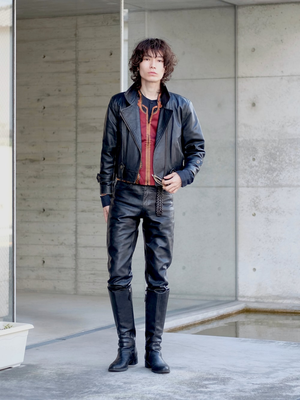 ブラック系のブーツ、ブラック系のライダースジャケット、レッド系のシャツ/ブラウスを着用したメンズの春コーディネートの3枚目の写真