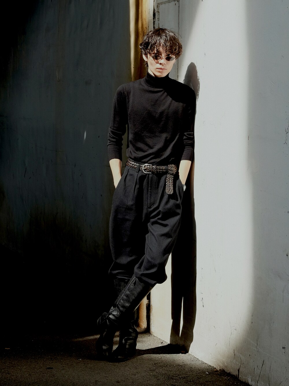 ブラック系のニット/セーター、ブラック系のスラックス、ブラック系のブーツを着用したメンズの夏コーディネートの3枚目の写真