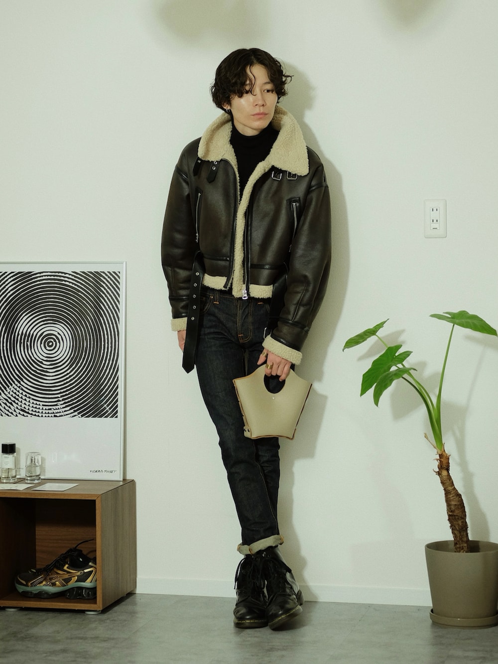 ベージュ系のハンドバッグ、ブラウン系のジャケット/アウター、ブルー系のデニムパンツを着用したメンズの冬コーディネートの3枚目の写真