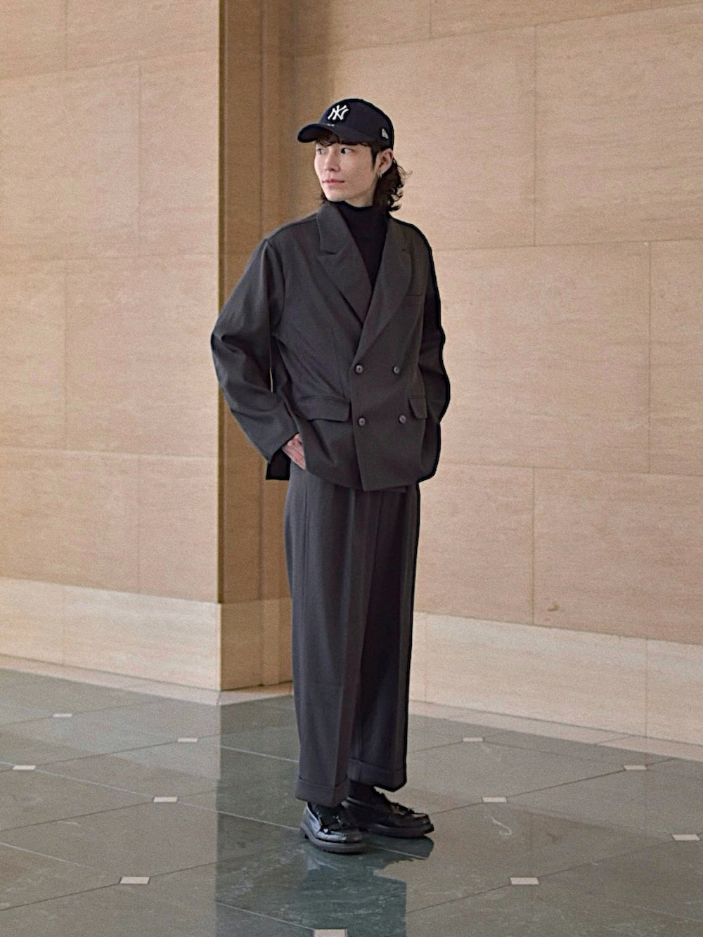 グレー系のテーラードジャケット、グレー系のスラックス、ブラック系のニット/セーターを着用したメンズの冬コーディネートの4枚目の写真