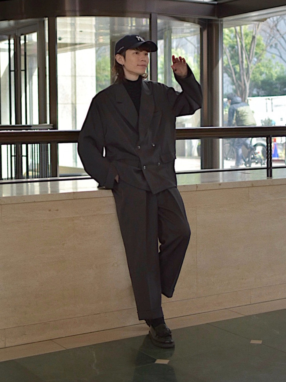 グレー系のテーラードジャケット、グレー系のスラックス、ブラック系のニット/セーターを着用したメンズの冬コーディネートの2枚目の写真