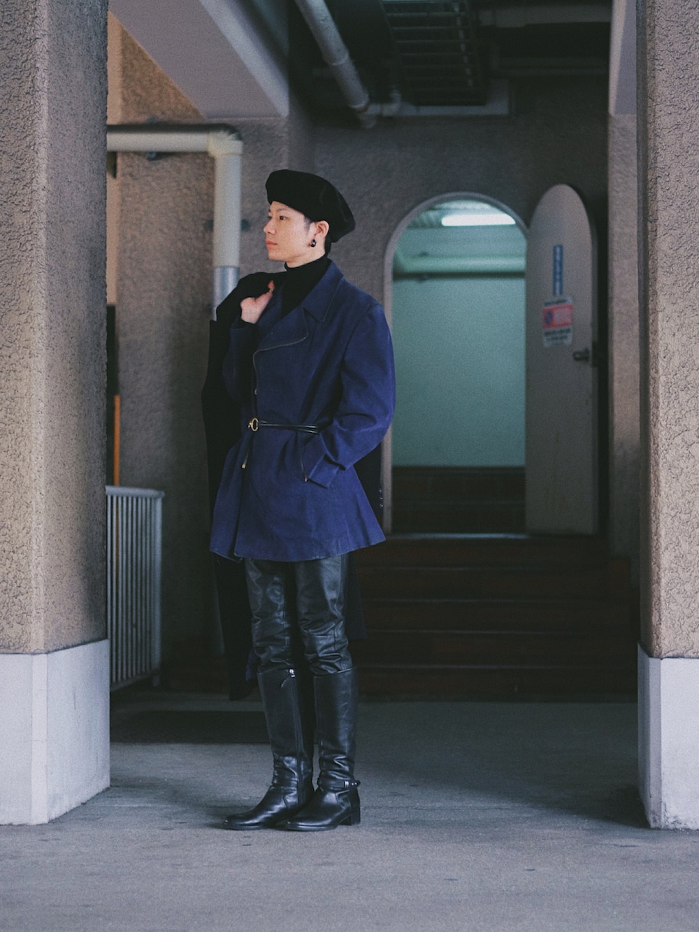 ブラック系のチェスターコート、パープル系のジャケット/アウター、ブラック系のパンツを着用したメンズの春コーディネートの2枚目の写真