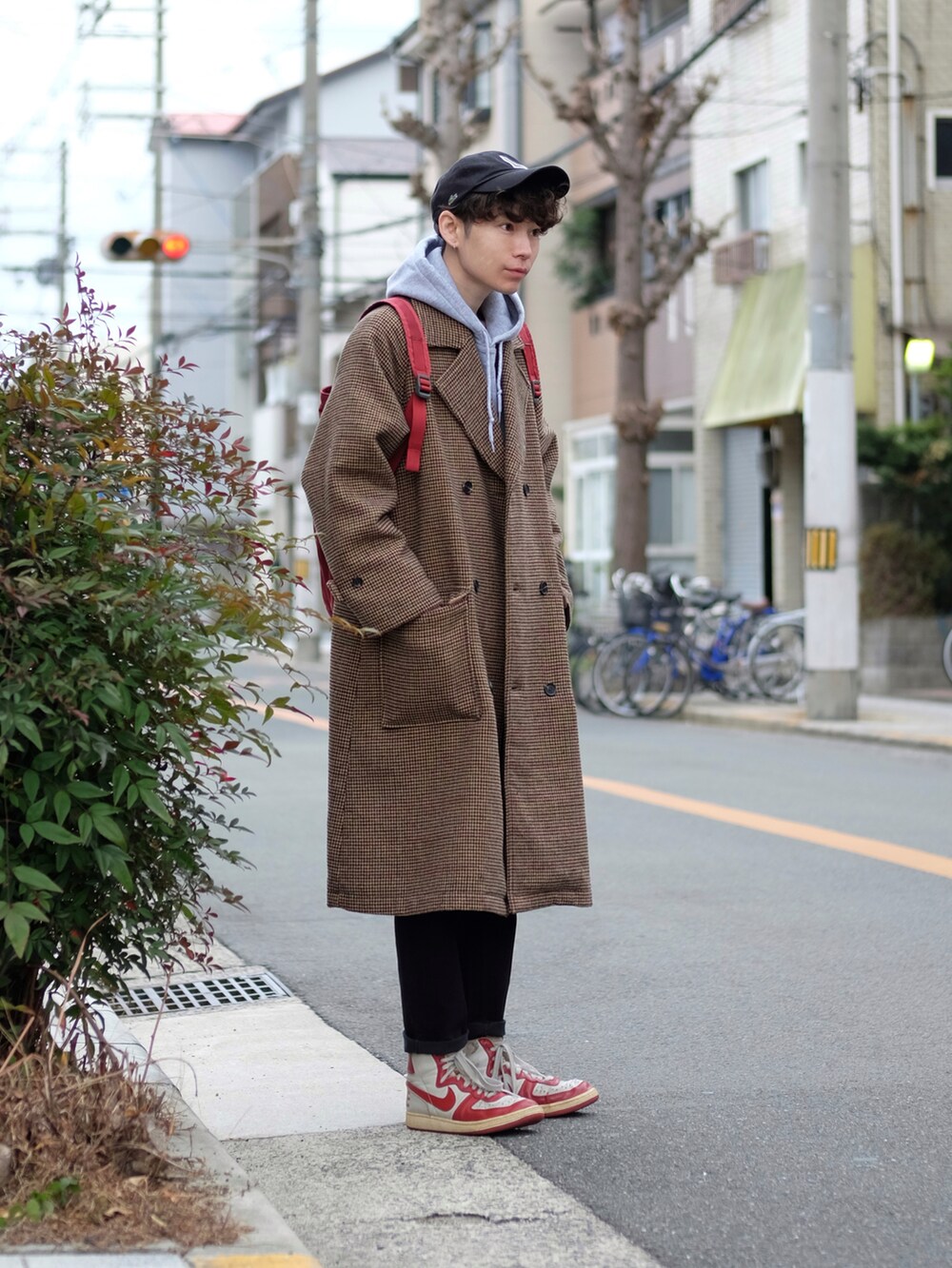 その他のチェスターコート、グレー系のパーカー、レッド系のバックパック/リュックを着用したメンズの冬コーディネートの2枚目の写真