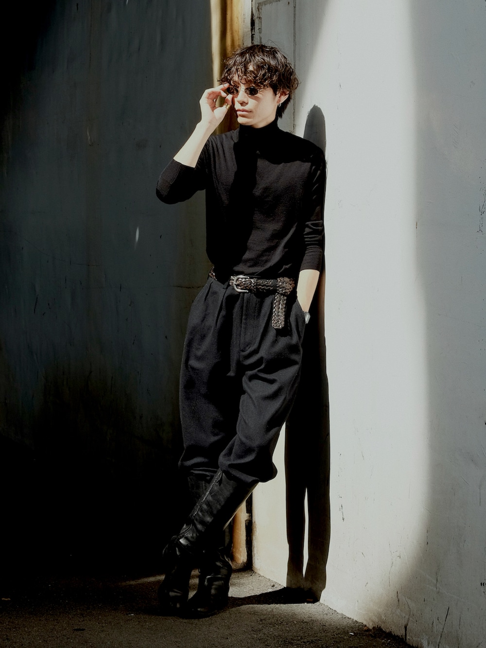 ブラック系のニット/セーター、ブラック系のスラックス、ブラック系のブーツを着用したメンズの夏コーディネートの2枚目の写真