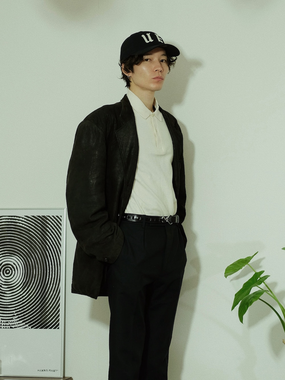 ブラック系のテーラードジャケット、ホワイト系のポロシャツ、ブラック系のスラックスを着用したメンズの冬コーディネートの3枚目の写真