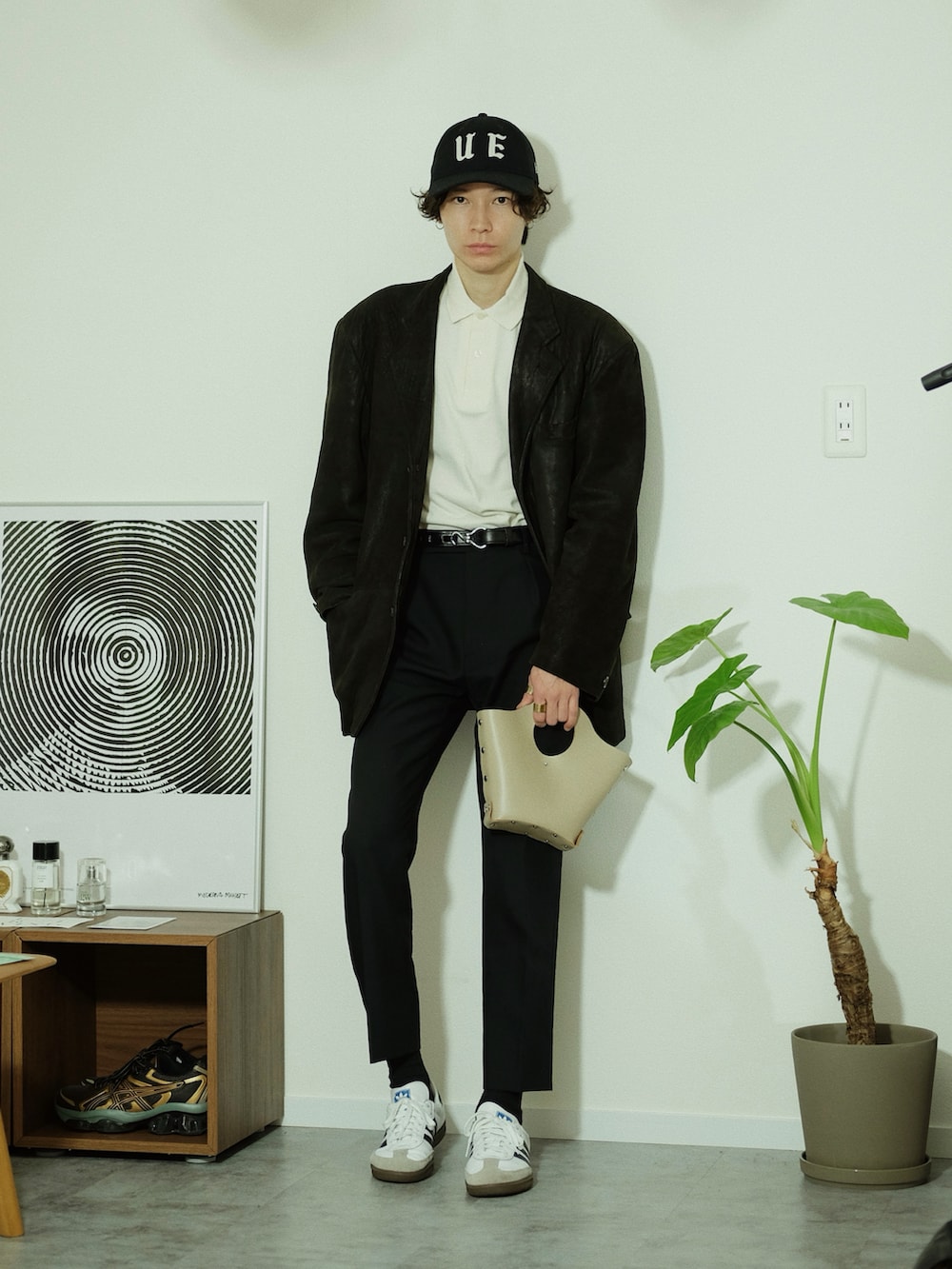 ブラック系のテーラードジャケット、ホワイト系のポロシャツ、ブラック系のスラックスを着用したメンズの冬コーディネートの2枚目の写真