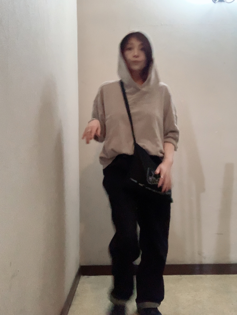 ベージュ系のパーカー、ブルー系のデニムパンツ、ブラック系のブーツを着用したレディースの秋コーディネートの4枚目の写真