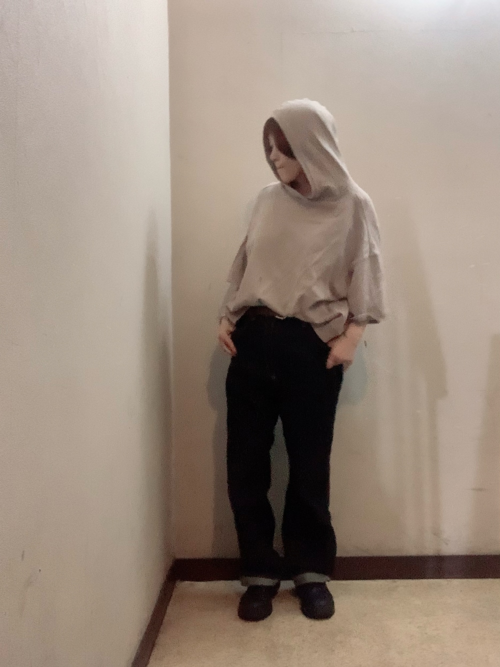 ベージュ系のパーカー、ブルー系のデニムパンツ、ブラック系のブーツを着用したレディースの秋コーディネートの3枚目の写真