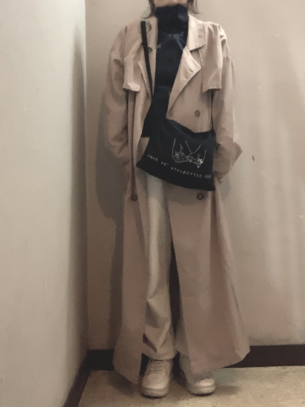 ブラック系のショルダーバッグ、ブルー系のジャージ、ベージュ系のトレンチコートを着用したレディースの秋コーディネートの3枚目の写真