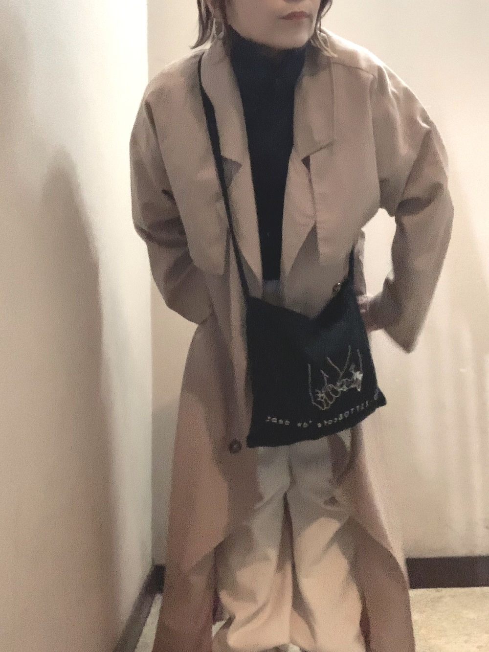 ブラック系のショルダーバッグ、ブルー系のジャージ、ベージュ系のトレンチコートを着用したレディースの秋コーディネートの2枚目の写真