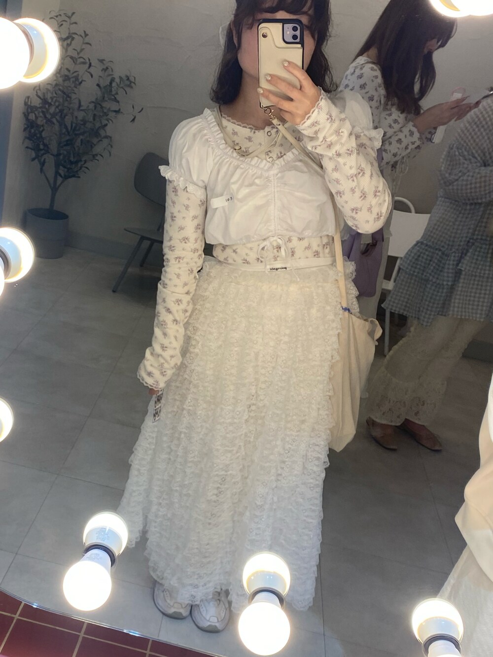 ホワイト系のスカート、ホワイト系のTシャツ/カットソー、ホワイト系のバレッタ/ヘアクリップを着用したレディースの春コーディネートの2枚目の写真