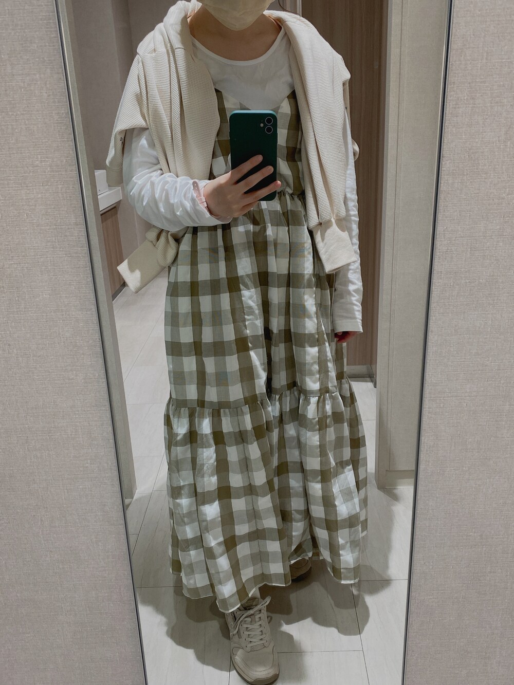 ホワイト系のカーディガン/ボレロ、グリーン系のワンピース、グレー系のスニーカーを着用したレディースの春コーディネートの2枚目の写真