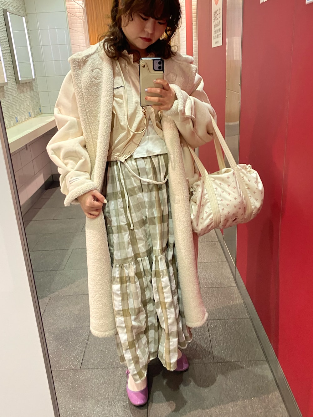 ホワイト系のダッフルコート、グリーン系のワンピース、ホワイト系のTシャツ/カットソーを着用したレディースの冬コーディネートの4枚目の写真