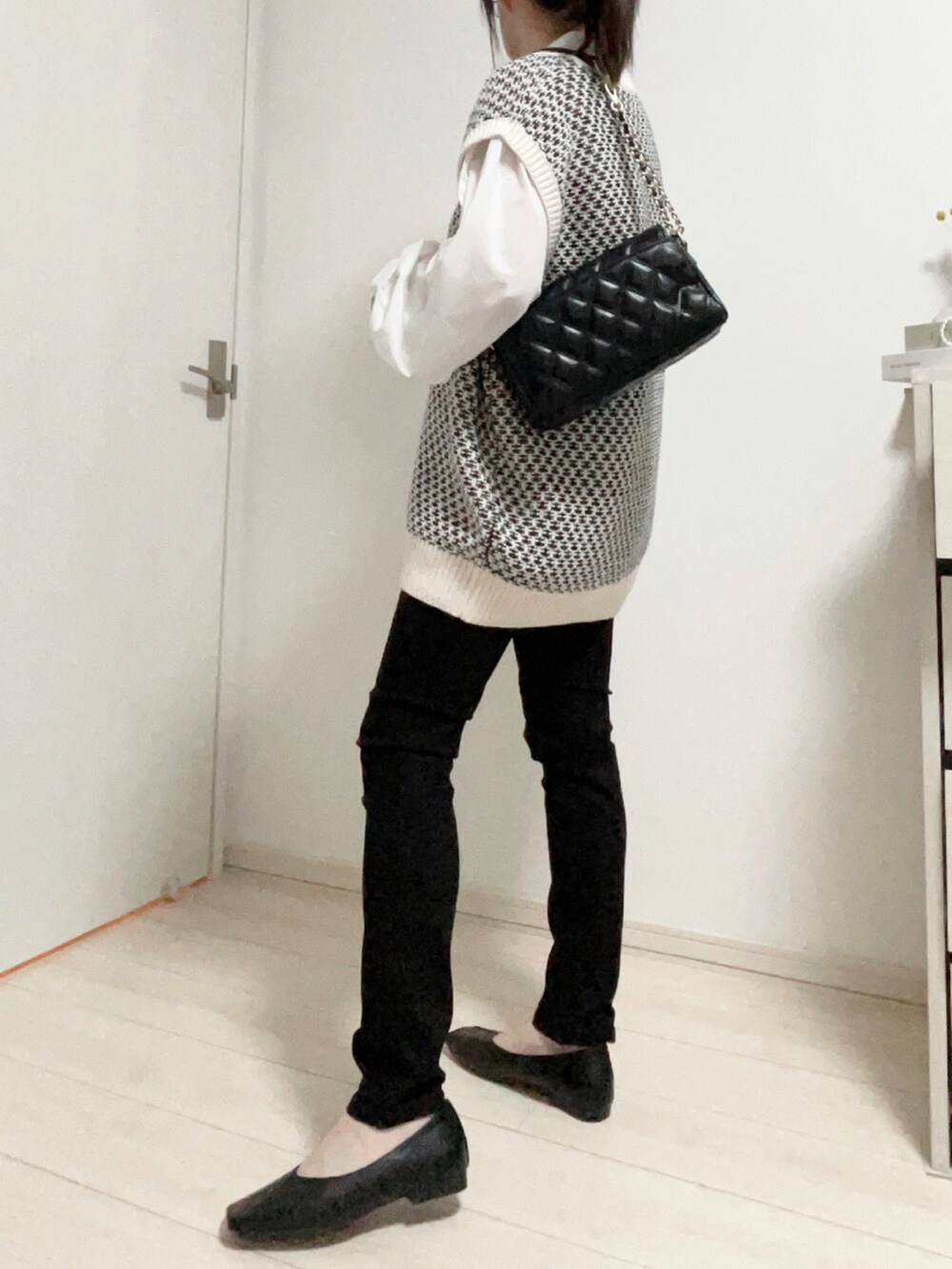 ホワイト系のベスト、ホワイト系のシャツ/ブラウス、ブラック系のデニムパンツを着用したレディースの秋コーディネートの2枚目の写真