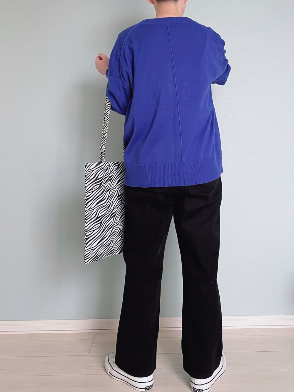 ブラック系のサロペット/オーバーオール、ブルー系のカーディガン/ボレロ、ホワイト系のTシャツ/カットソーを着用したレディースの春コーディネートの4枚目の写真