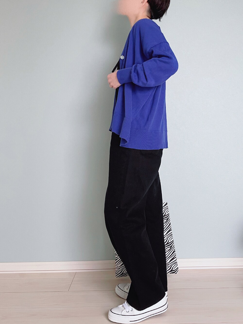 ブラック系のサロペット/オーバーオール、ブルー系のカーディガン/ボレロ、ホワイト系のTシャツ/カットソーを着用したレディースの春コーディネートの3枚目の写真