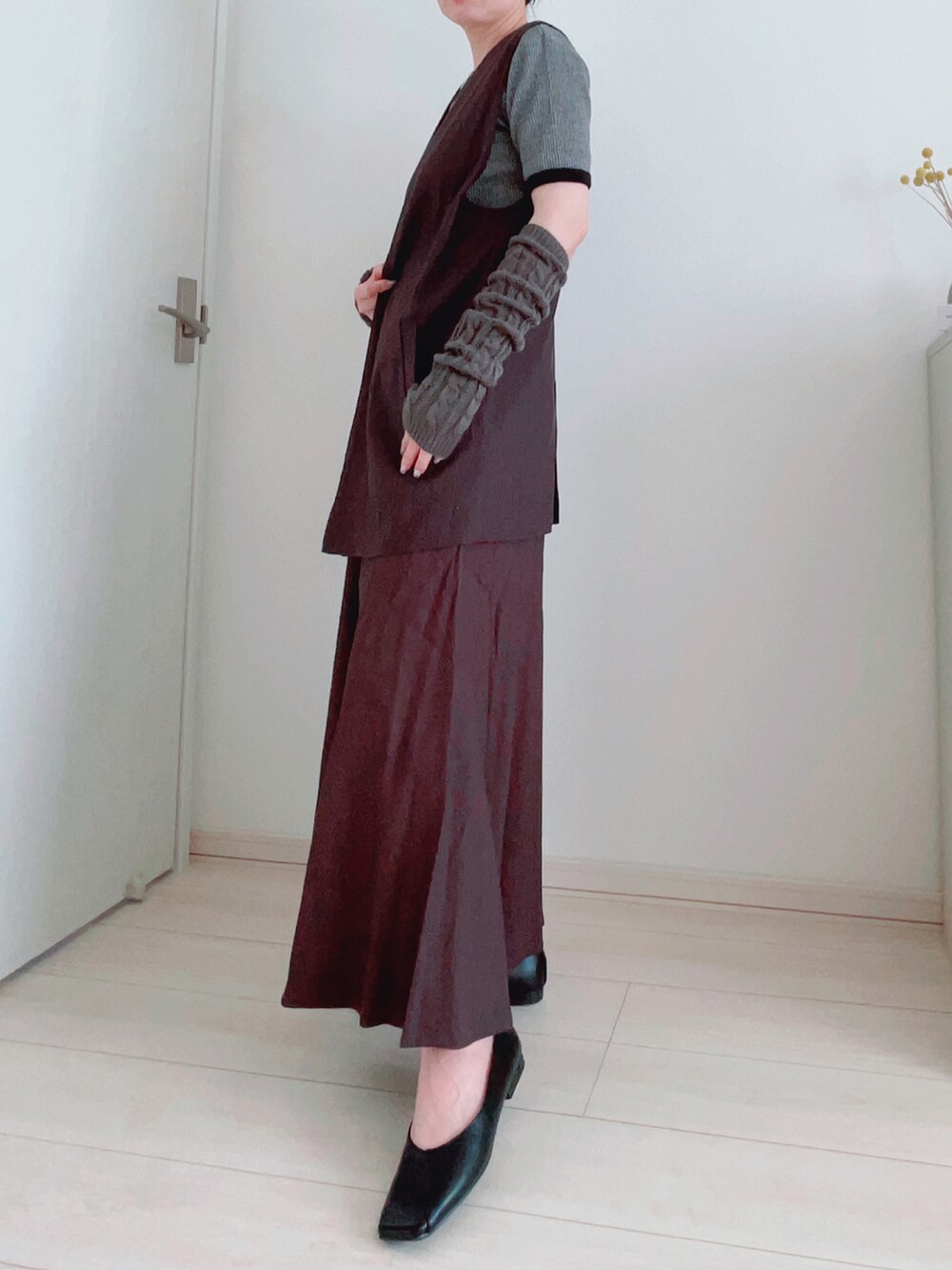 ブラック系のシューズ、グレー系のベスト、グレー系のスカートを着用したレディースの夏コーディネートの2枚目の写真