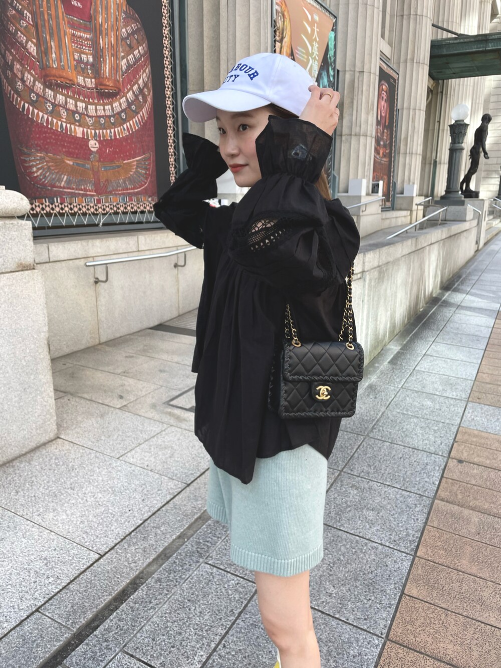 イエロー系のスニーカー、ブルー系のパンツ、ブラック系のシャツ/ブラウスを着用したレディースの春コーディネートの2枚目の写真