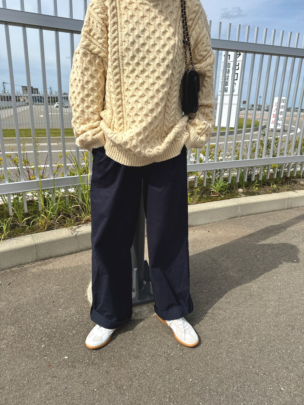 ブルー系のパンツ、ベージュ系のニット/セーター、ブラウン系の帽子を着用したレディースの秋コーディネートの2枚目の写真