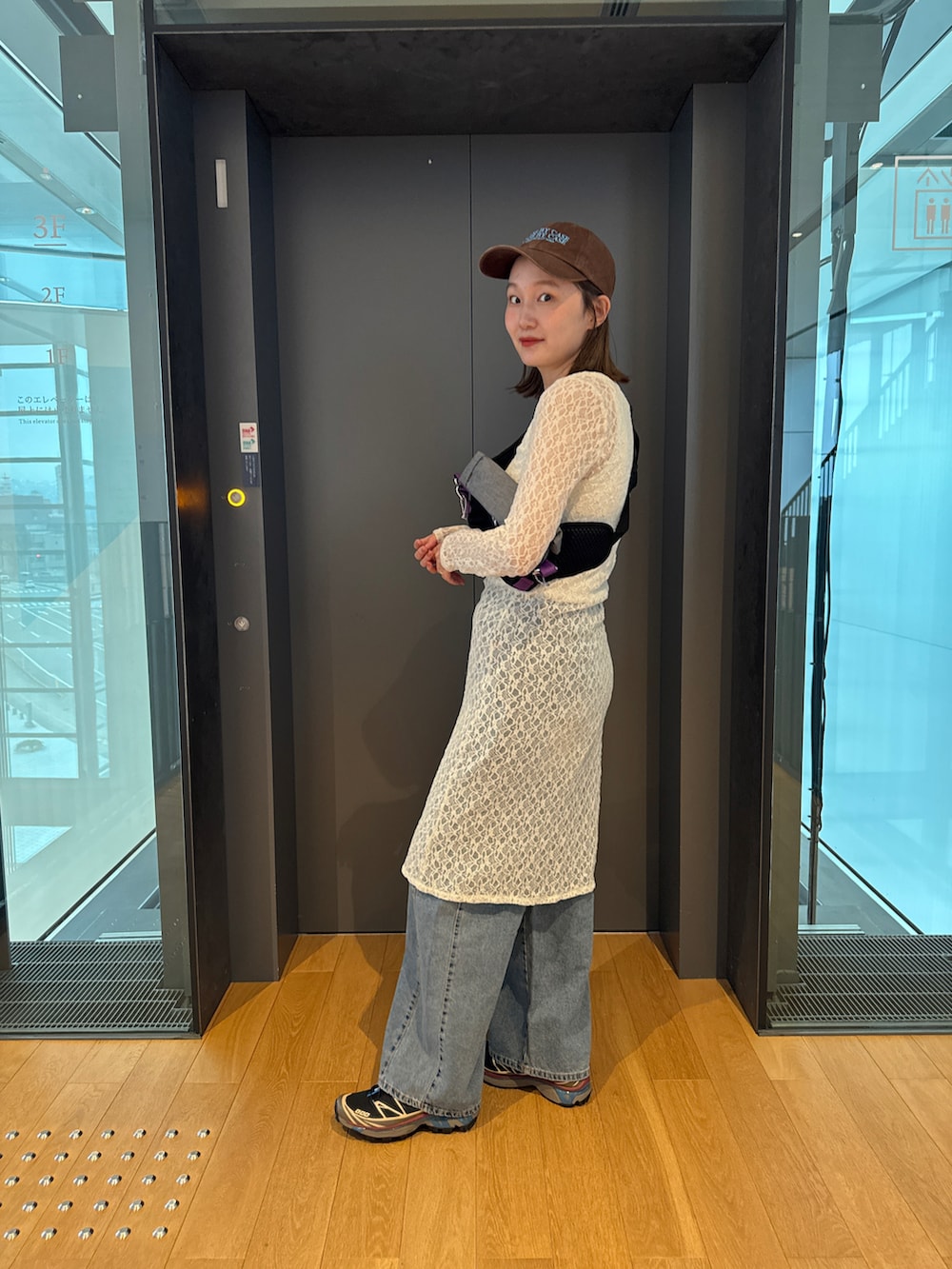 ホワイト系のワンピース/ドレス、ブラック系のボディバッグ/ウエストポーチ、ブラック系のスニーカーを着用したレディースの春コーディネートの2枚目の写真