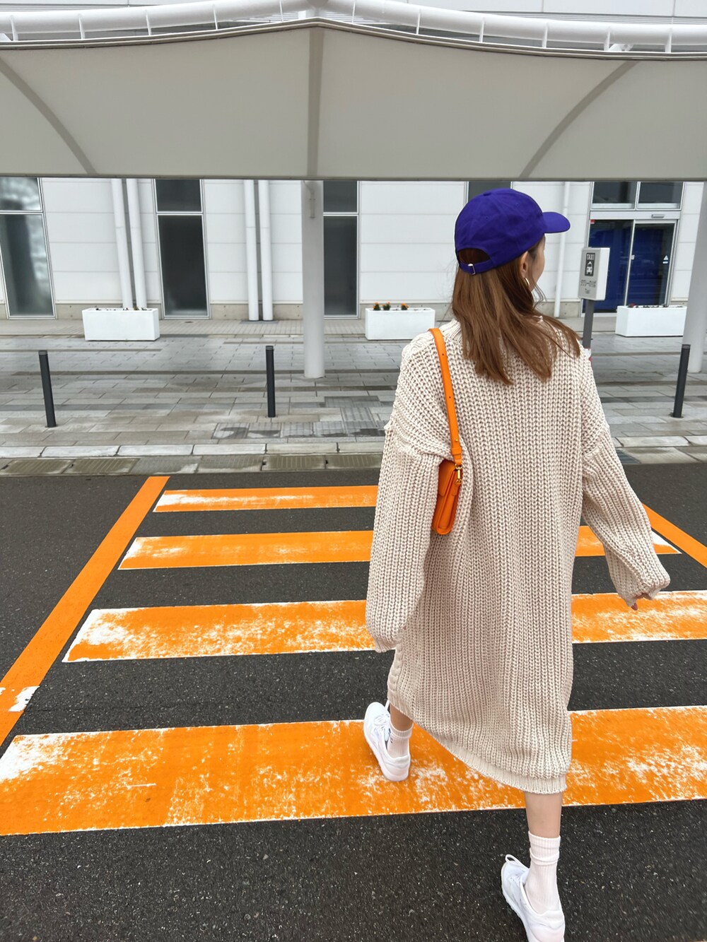 ベージュ系のワンピース/ドレス、ブルー系のソックス/靴下、パープル系のキャップを着用したレディースの秋コーディネートの2枚目の写真