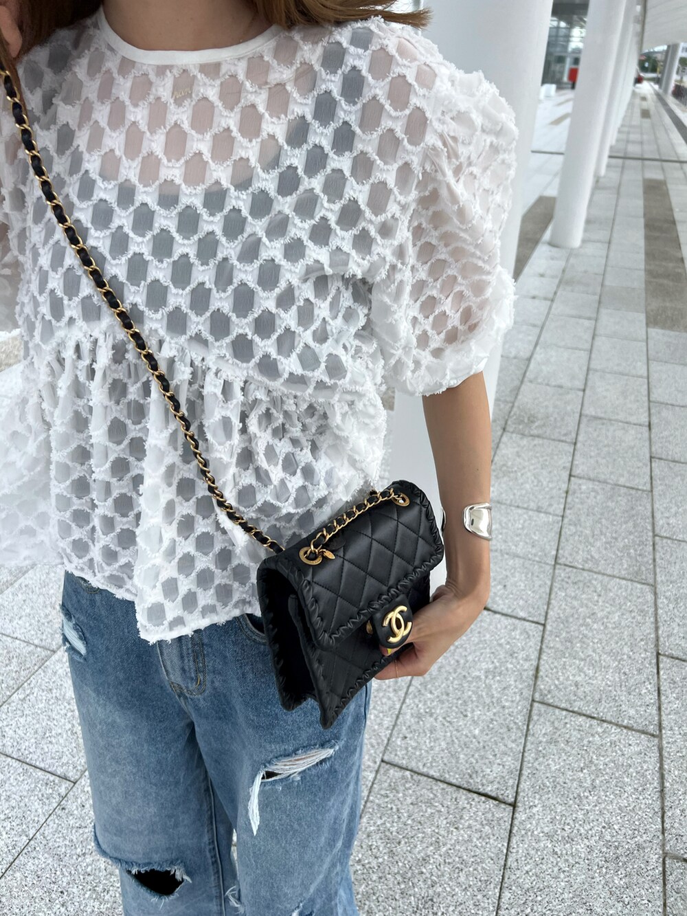 オレンジ系のシューズ、ブルー系のデニムパンツ、ホワイト系のシャツ/ブラウスを着用したレディースの夏コーディネートの2枚目の写真