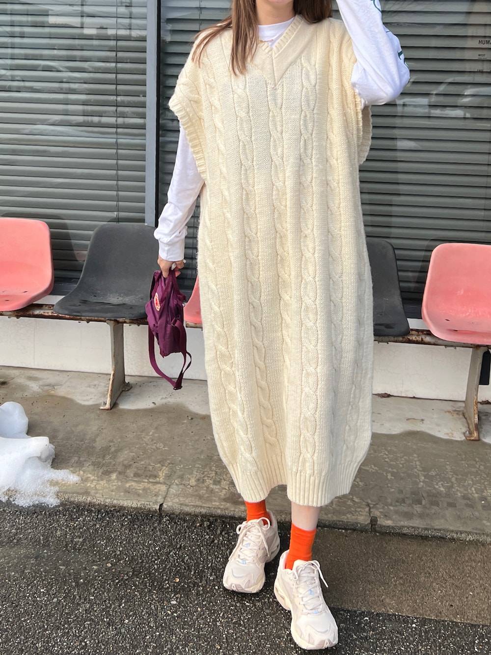 ホワイト系のニット/セーター、ブラック系のトップス、ベージュ系のスニーカーを着用したレディースの冬コーディネートの2枚目の写真