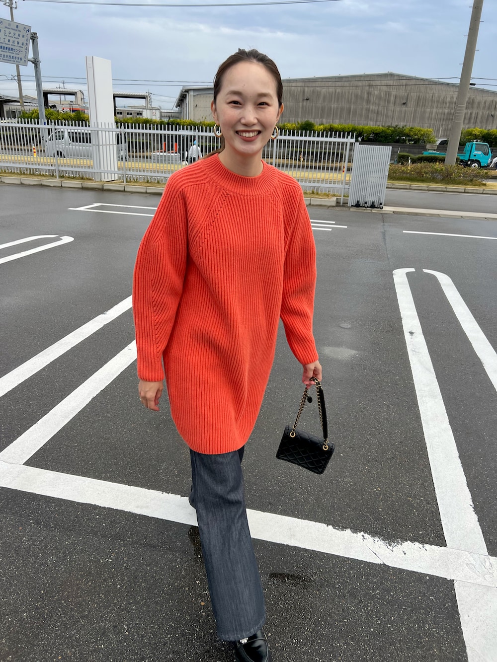 ブラック系のローファー、ブラック系のデニムパンツ、オレンジ系のチュニックを着用したレディースの秋コーディネートの2枚目の写真