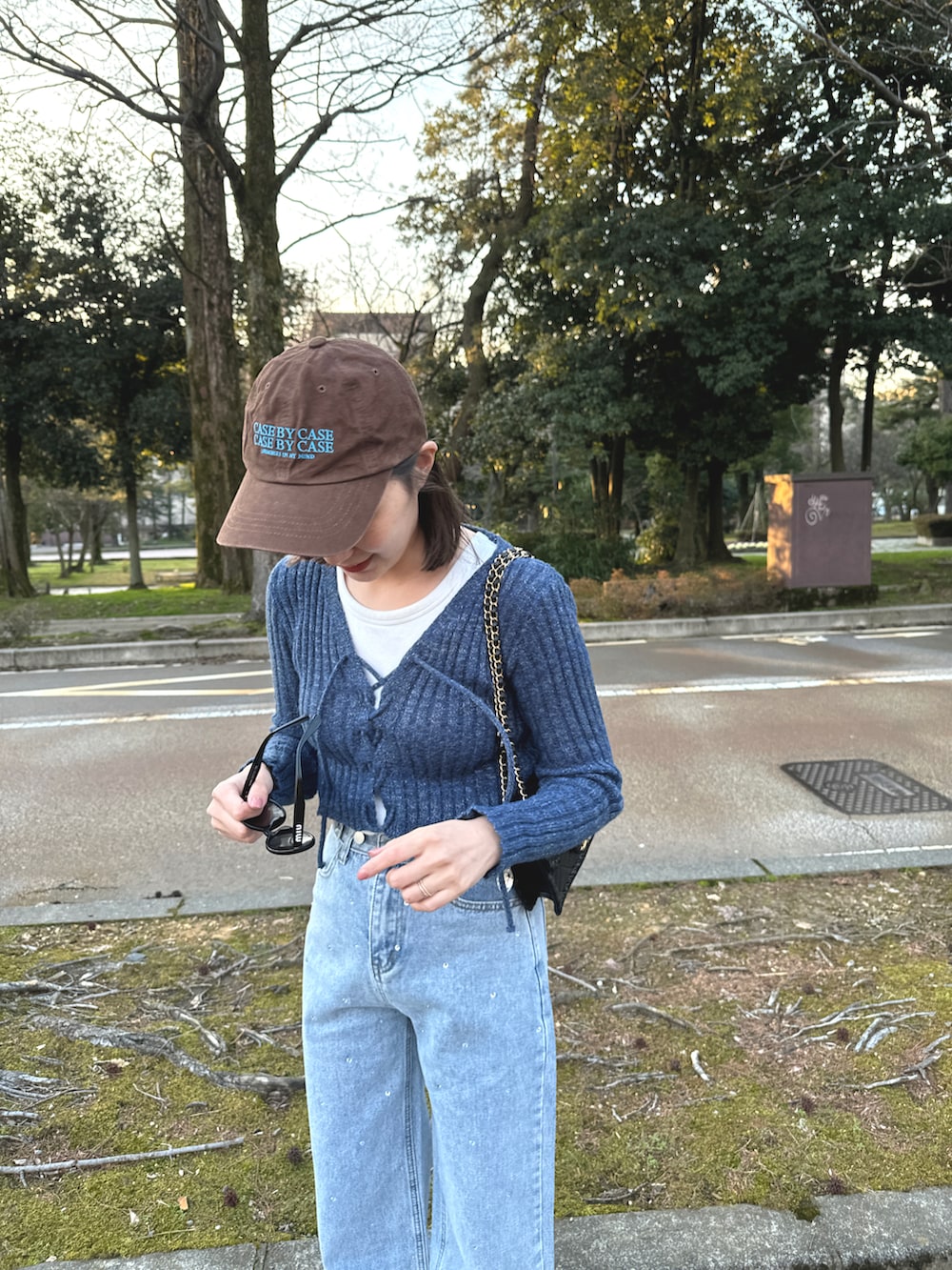 ブルー系のデニムパンツ、ブルー系のニット/セーター、ブラウン系の帽子を着用したレディースの春コーディネートの3枚目の写真