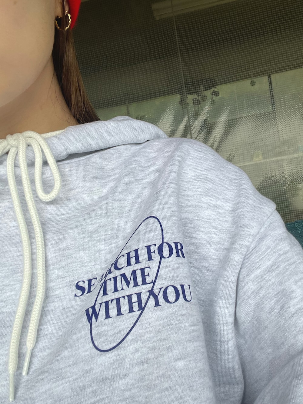 ブルー系のパンツ、グレー系のパーカー、レッド系のニットキャップ/ビーニーを着用したレディースの秋コーディネートの2枚目の写真