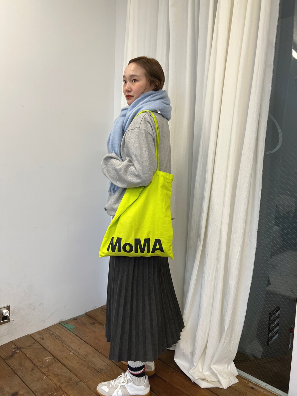 グレー系のスカート、グレー系のスウェット、ブルー系のマフラーを着用したレディースの冬コーディネートの3枚目の写真