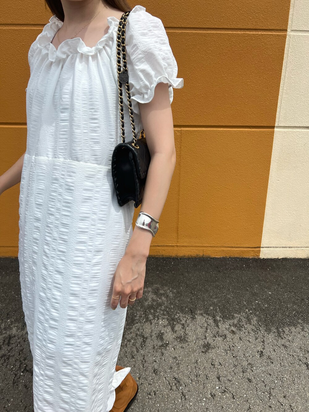 ホワイト系のワンピース/ドレス、ブラウン系のブーツ、ブルー系のキャップを着用したレディースの夏コーディネートの3枚目の写真