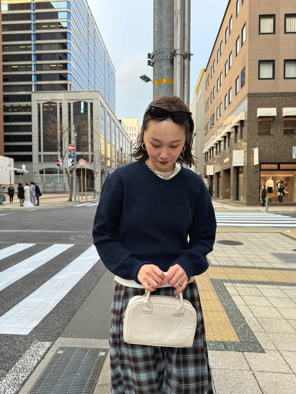 ブルー系のスカート、ブルー系のニット/セーター、ブラック系のスニーカーを着用したレディースの冬コーディネートの4枚目の写真