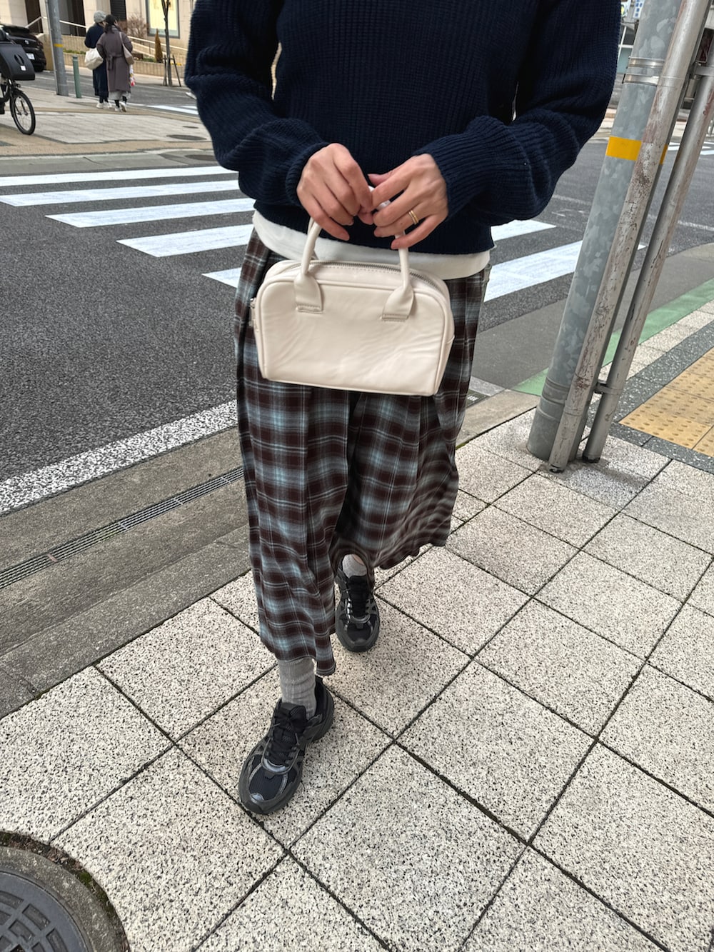 ブルー系のスカート、ブルー系のニット/セーター、ブラック系のスニーカーを着用したレディースの冬コーディネートの3枚目の写真