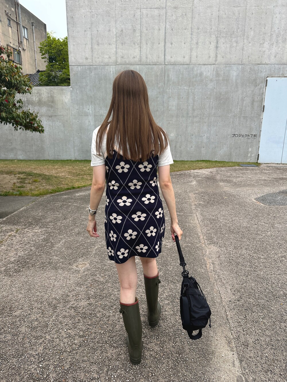 ブラック系のバッグ、ブルー系のワンピース/ドレス、ベージュ系のレインシューズを着用したレディースの春コーディネートの3枚目の写真