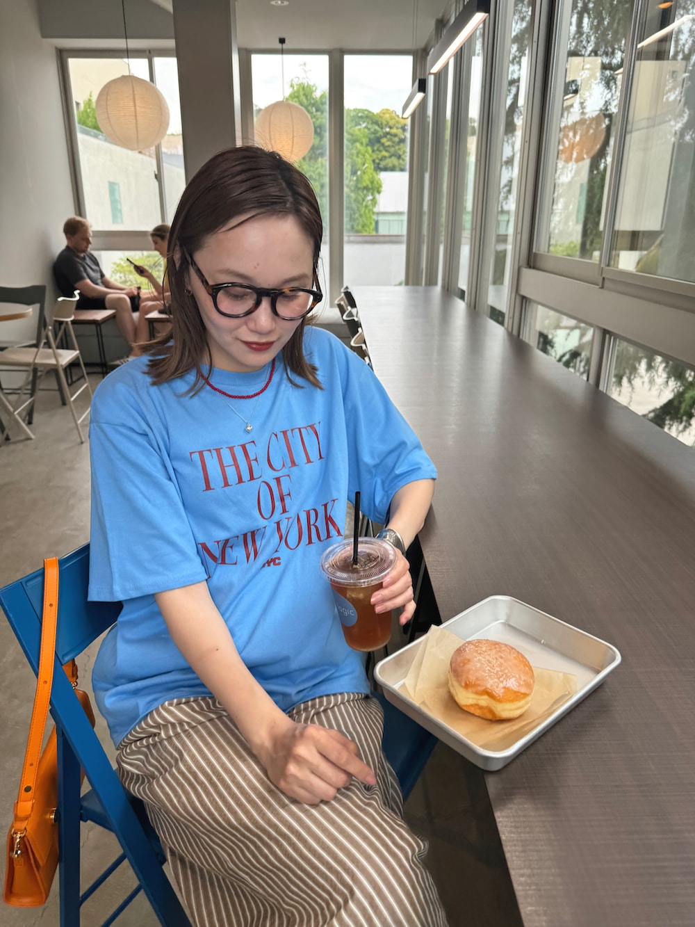 ブルー系のTシャツ/カットソー、ブラウン系のパンツ、ブラウン系のメガネを着用したレディースの春コーディネートの4枚目の写真