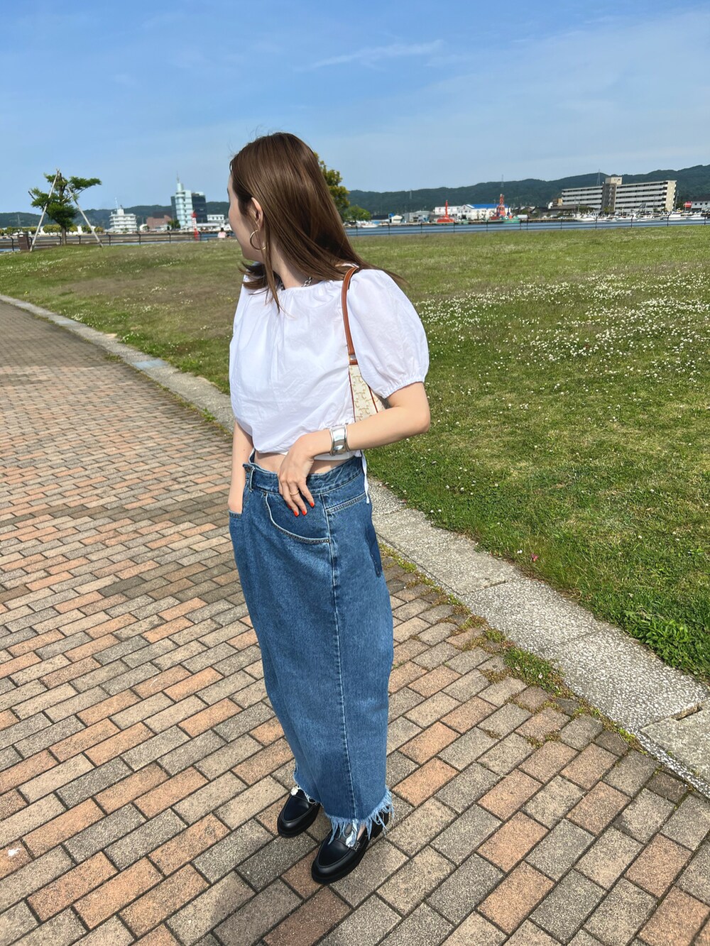 ブラック系のローファー、ブルー系のデニムパンツ、ホワイト系のシャツ/ブラウスを着用したレディースの春コーディネートの2枚目の写真