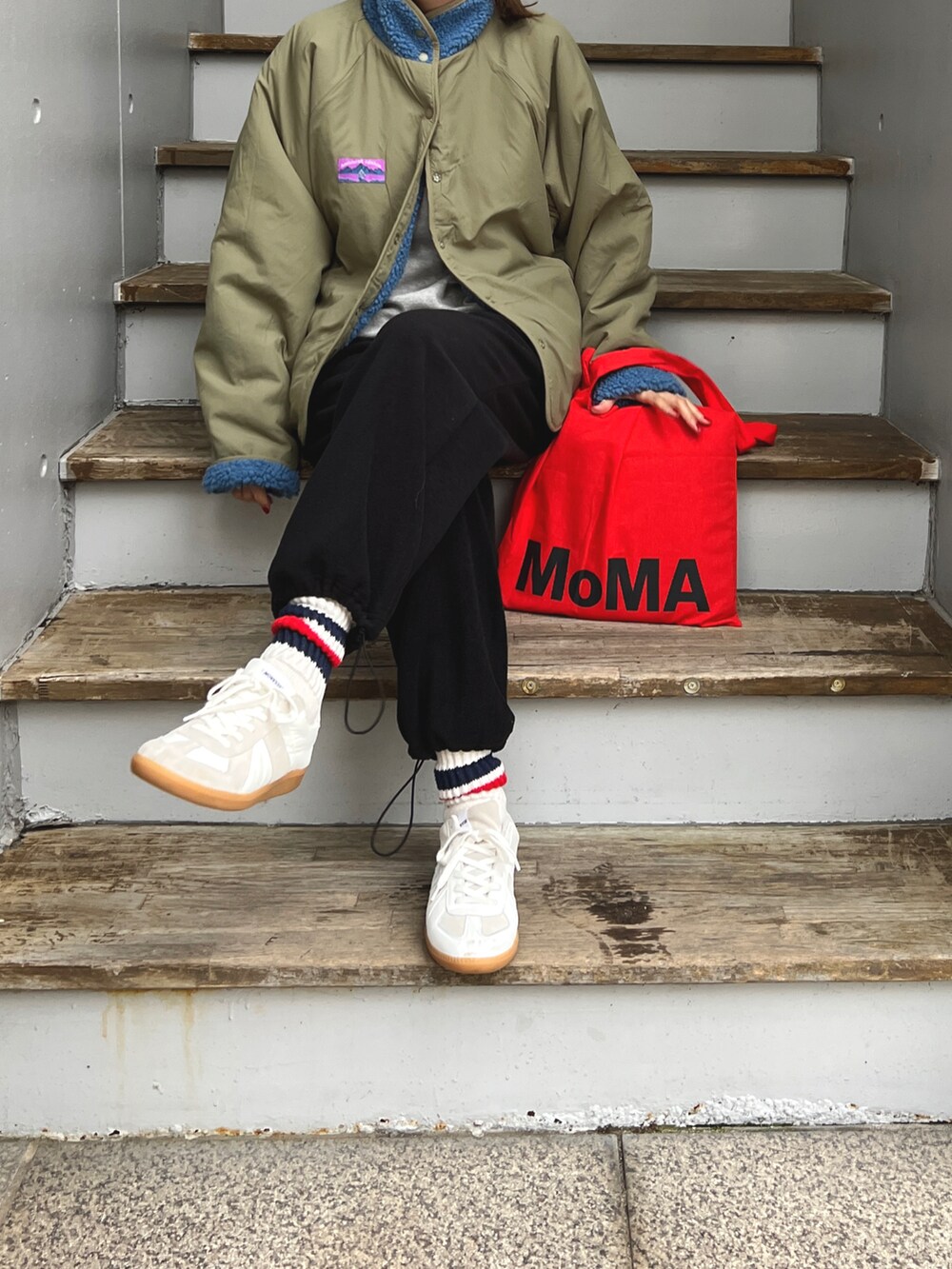 ブラック系のパンツ、ブルー系のジャケット/アウター、ホワイト系のスニーカーを着用したレディースの冬コーディネートの2枚目の写真