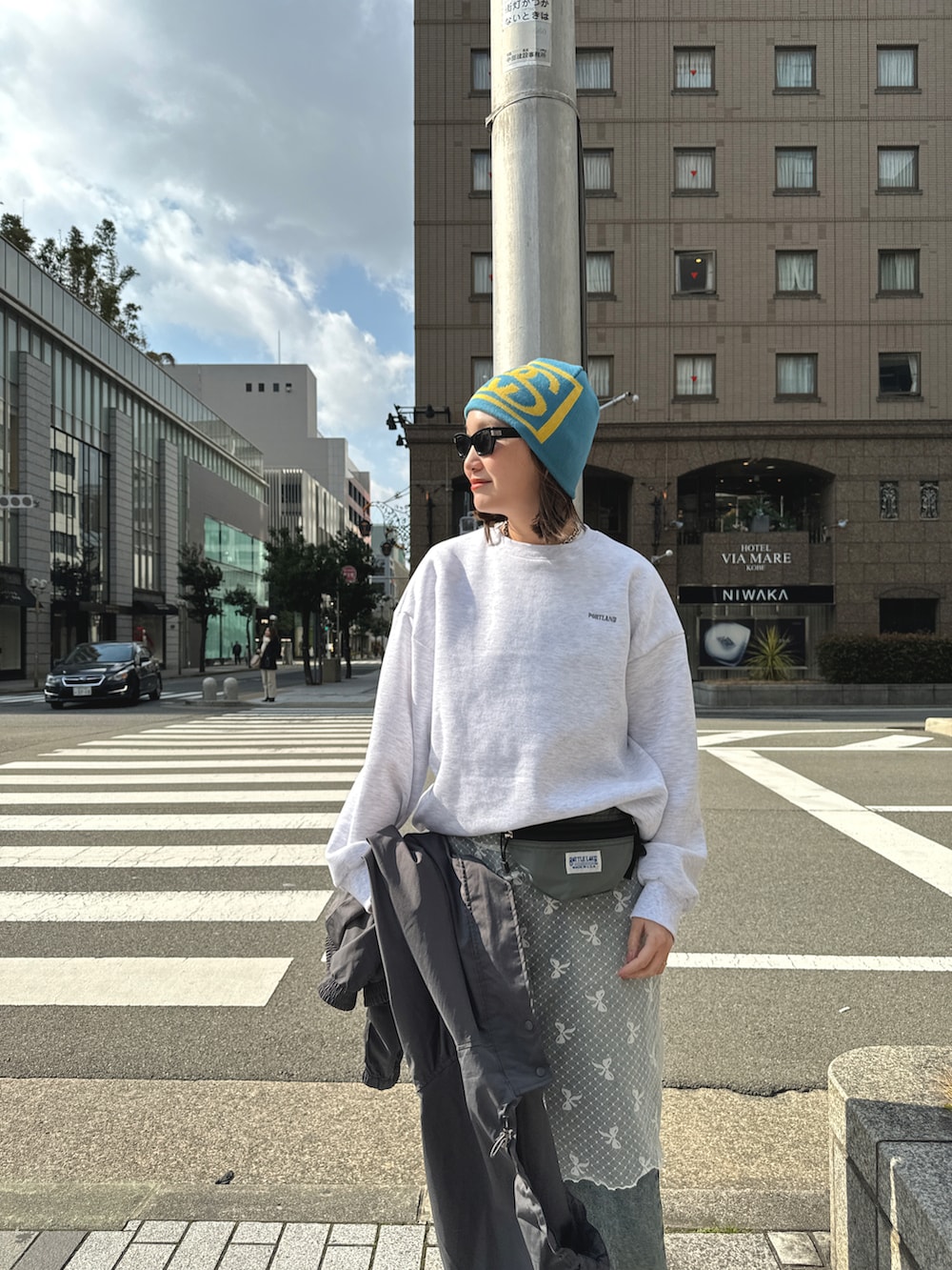 ブルー系のデニムパンツ、グレー系のジャケット/アウター、ホワイト系のスカートを着用したレディースの冬コーディネートの3枚目の写真