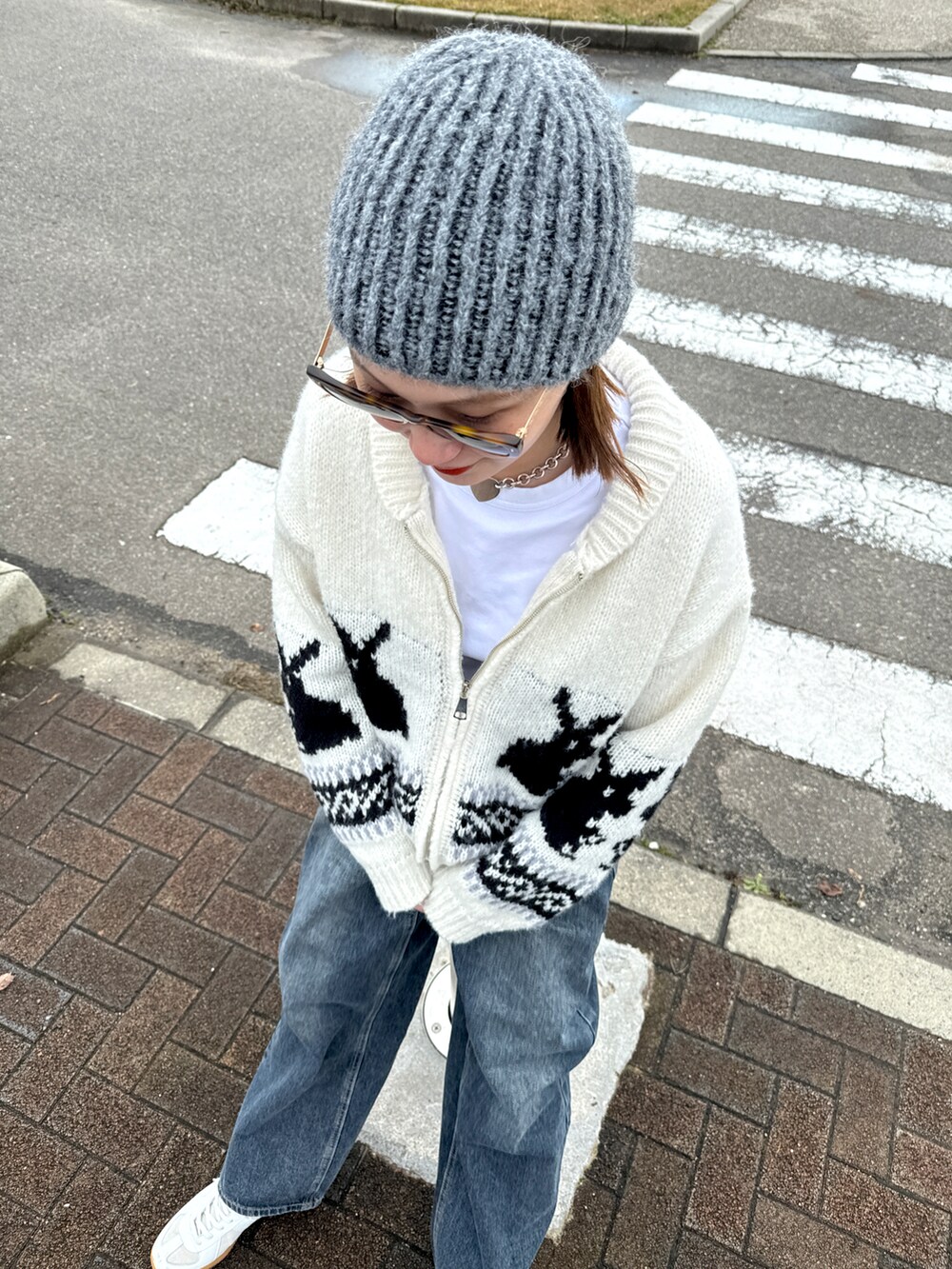 ホワイト系のスニーカー、ブルー系のデニムパンツ、ホワイト系のジャケット/アウターを着用したレディースの冬コーディネートの4枚目の写真