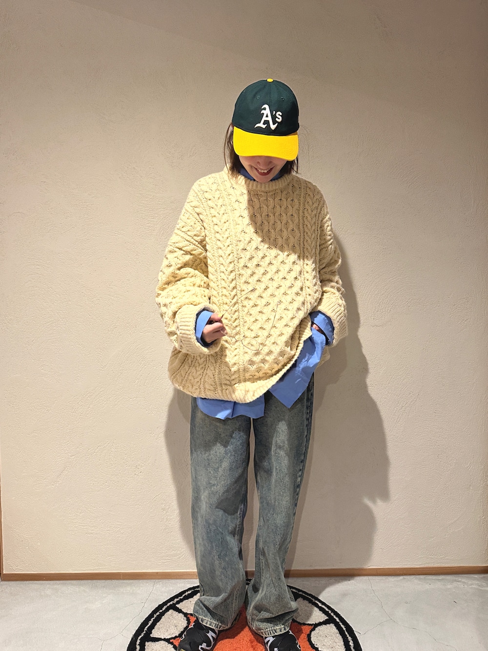 ブルー系のデニムパンツ、ブルー系のシャツ/ブラウス、ベージュ系のニット/セーターを着用したレディースの冬コーディネートの2枚目の写真