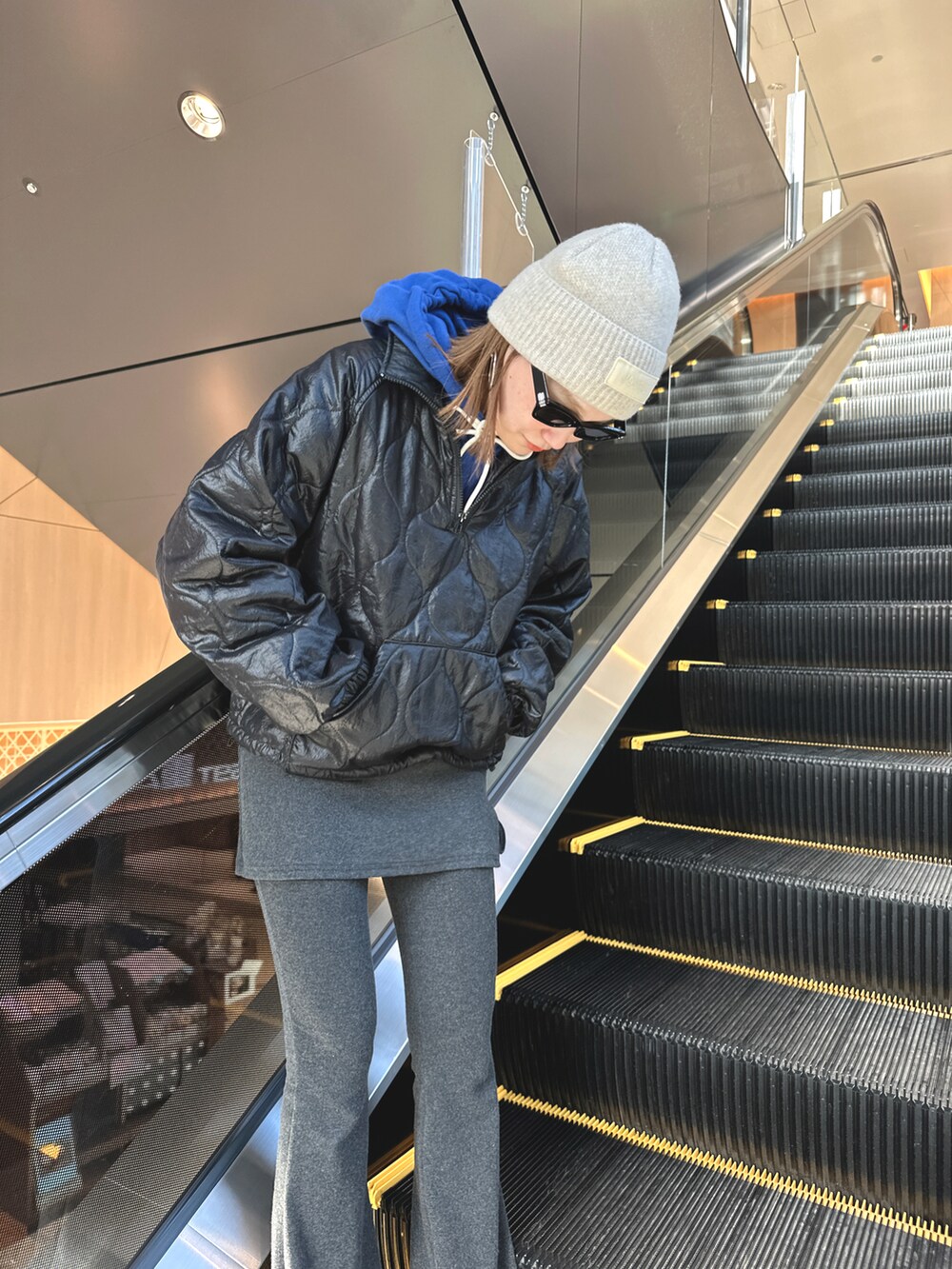 グレー系のパンツ、シルバー系のバッグ、ブラック系のスニーカーを着用したレディースの冬コーディネートの4枚目の写真