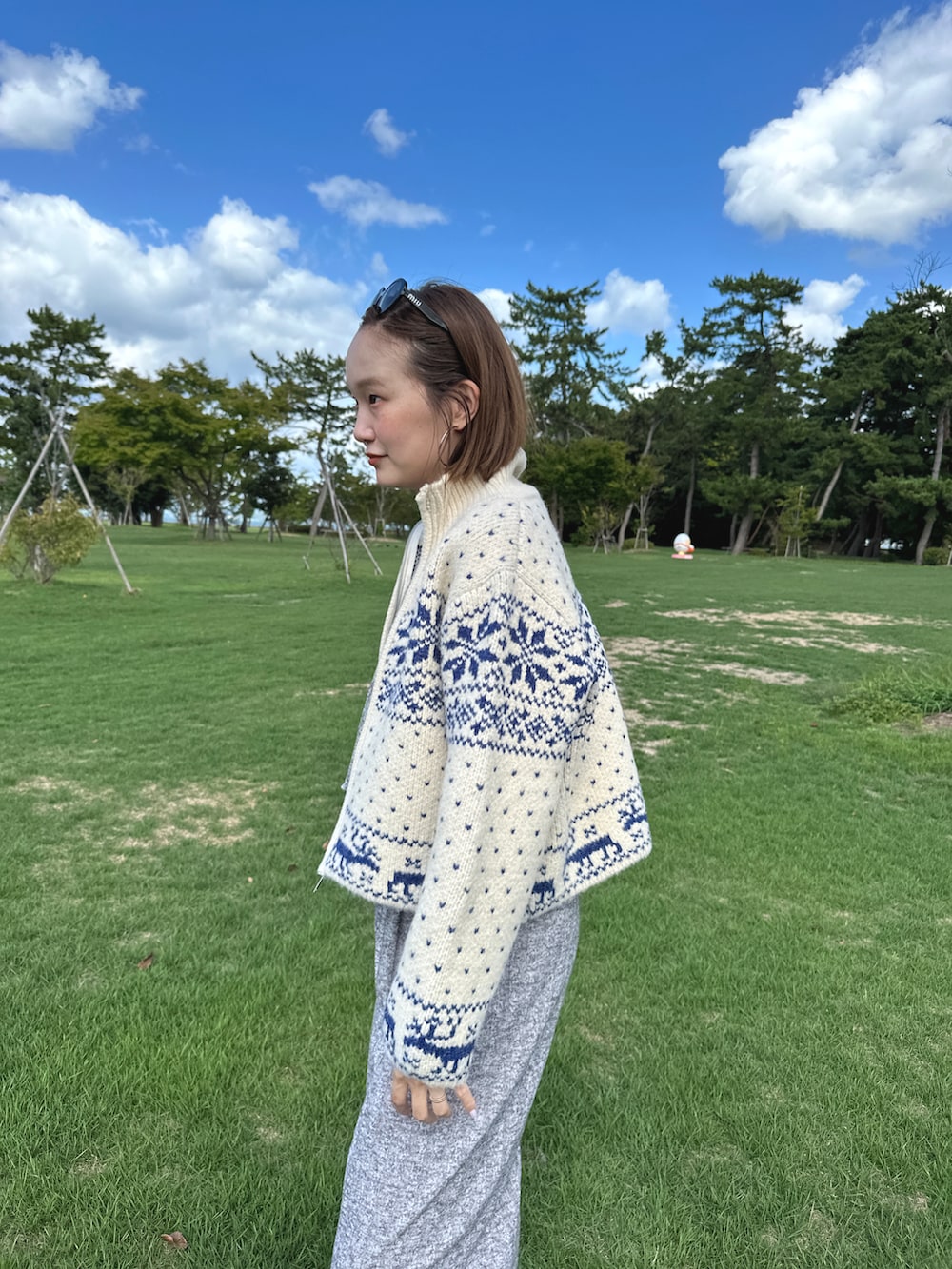 ベージュ系のカーディガン/ボレロ、グレー系のパンツ、ブラック系のサングラスを着用したレディースの秋コーディネートの2枚目の写真