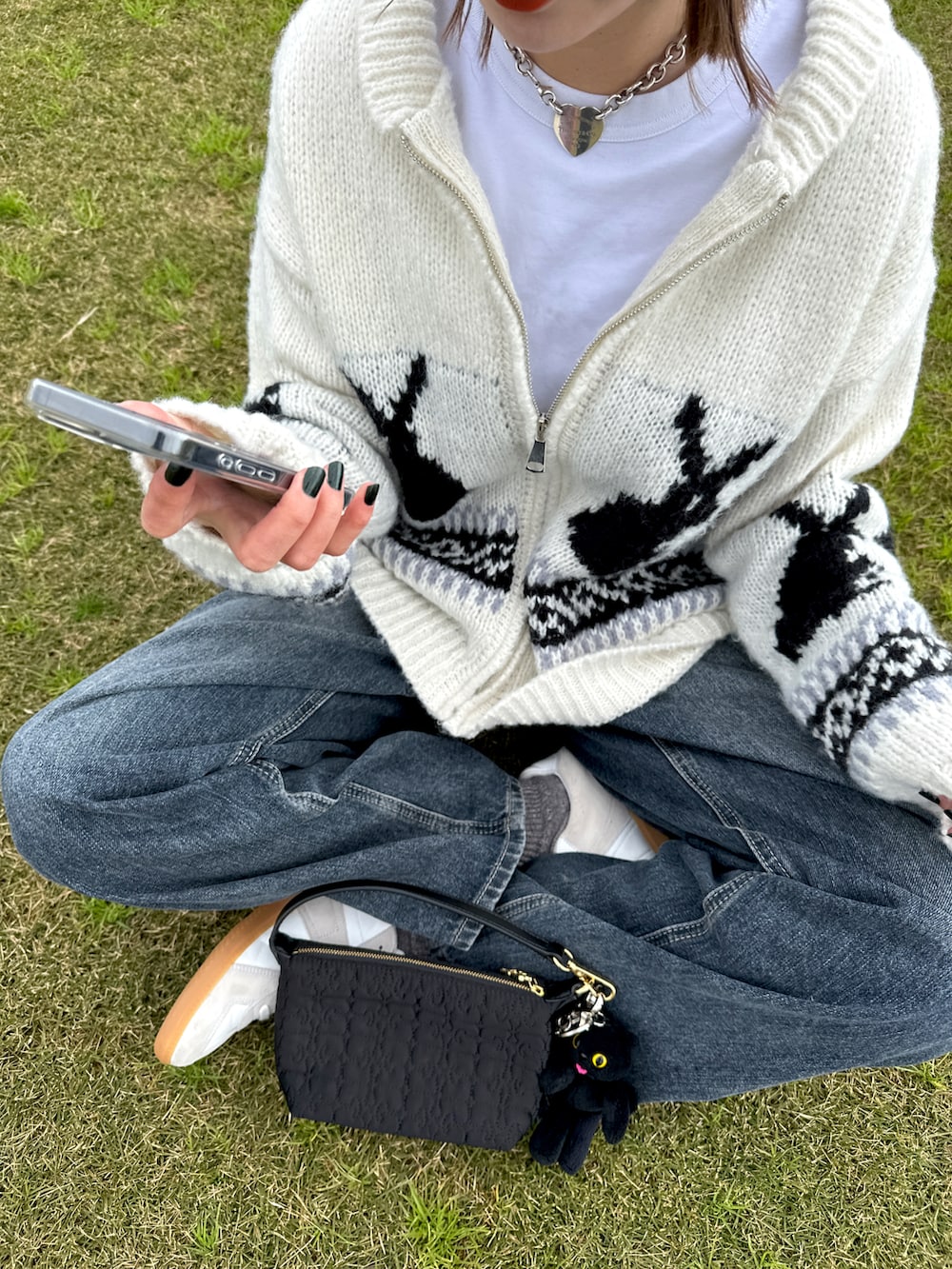 ホワイト系のスニーカー、ブルー系のデニムパンツ、ホワイト系のジャケット/アウターを着用したレディースの冬コーディネートの2枚目の写真