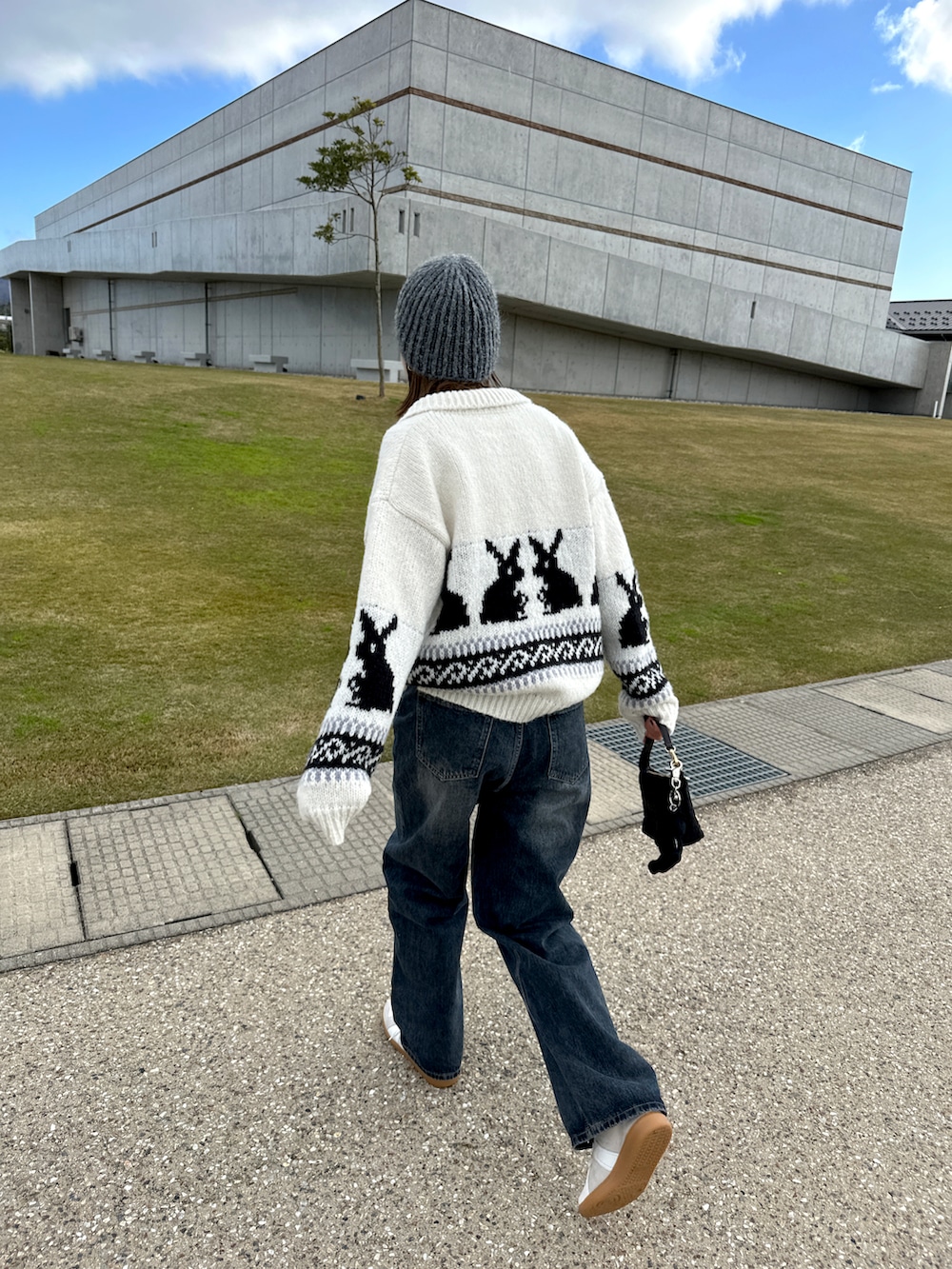 ホワイト系のスニーカー、ブルー系のデニムパンツ、ホワイト系のジャケット/アウターを着用したレディースの冬コーディネートの3枚目の写真