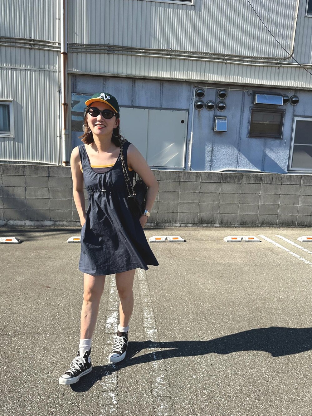 ブルー系のワンピース/ドレス、ブラウン系のスニーカー、グリーン系のキャップを着用したレディースの夏コーディネートの2枚目の写真