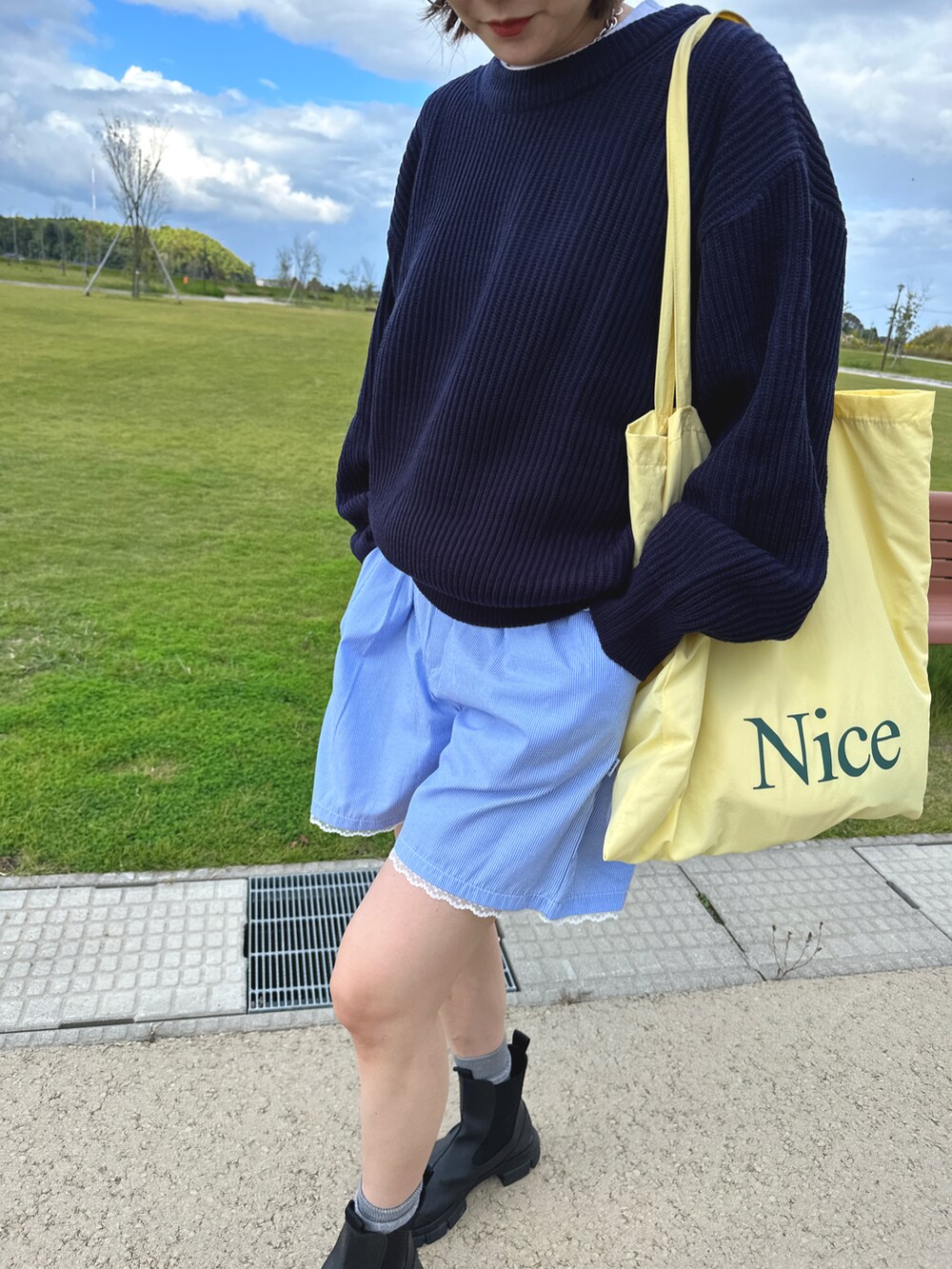 ブラック系のブーツ、ブルー系のパンツ、ブルー系のニット/セーターを着用したレディースの秋コーディネートの2枚目の写真