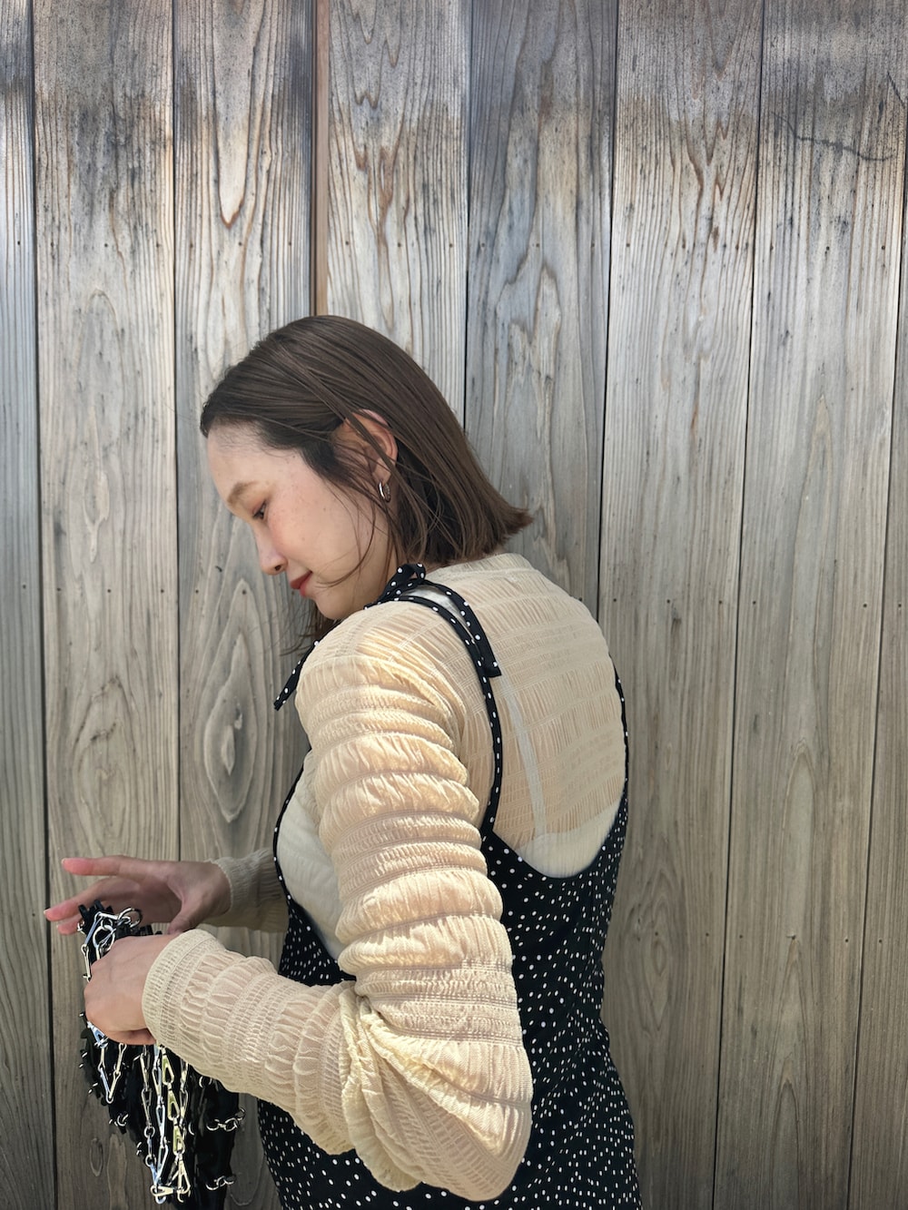 グリーン系のスニーカー、ブラック系のオールインワン・サロペット、ブラック系のショルダーバッグを着用したレディースの夏コーディネートの3枚目の写真