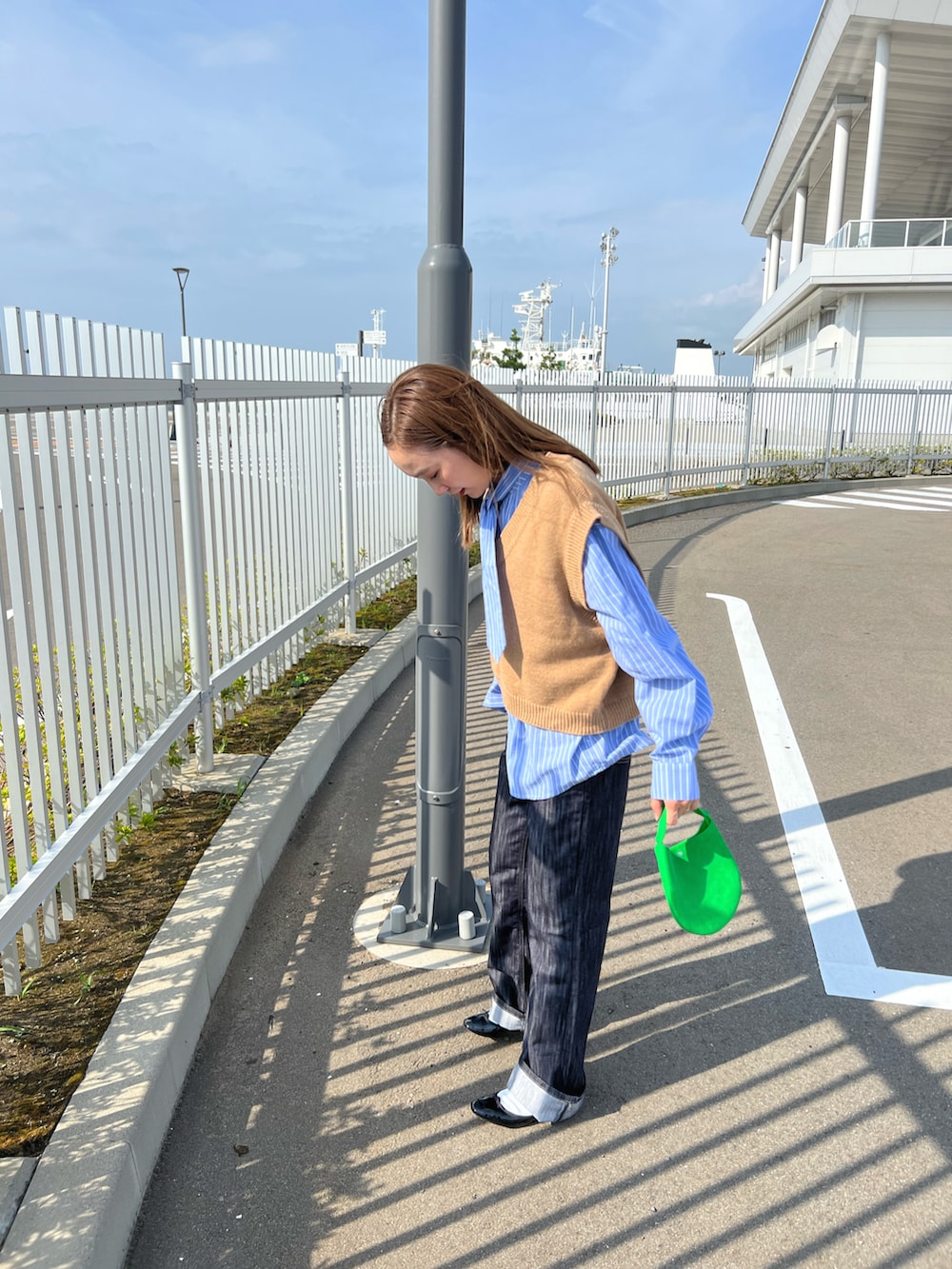 ブルー系のデニムパンツ、ブルー系のシャツ/ブラウス、ブラウン系のベストを着用したレディースの秋コーディネートの2枚目の写真