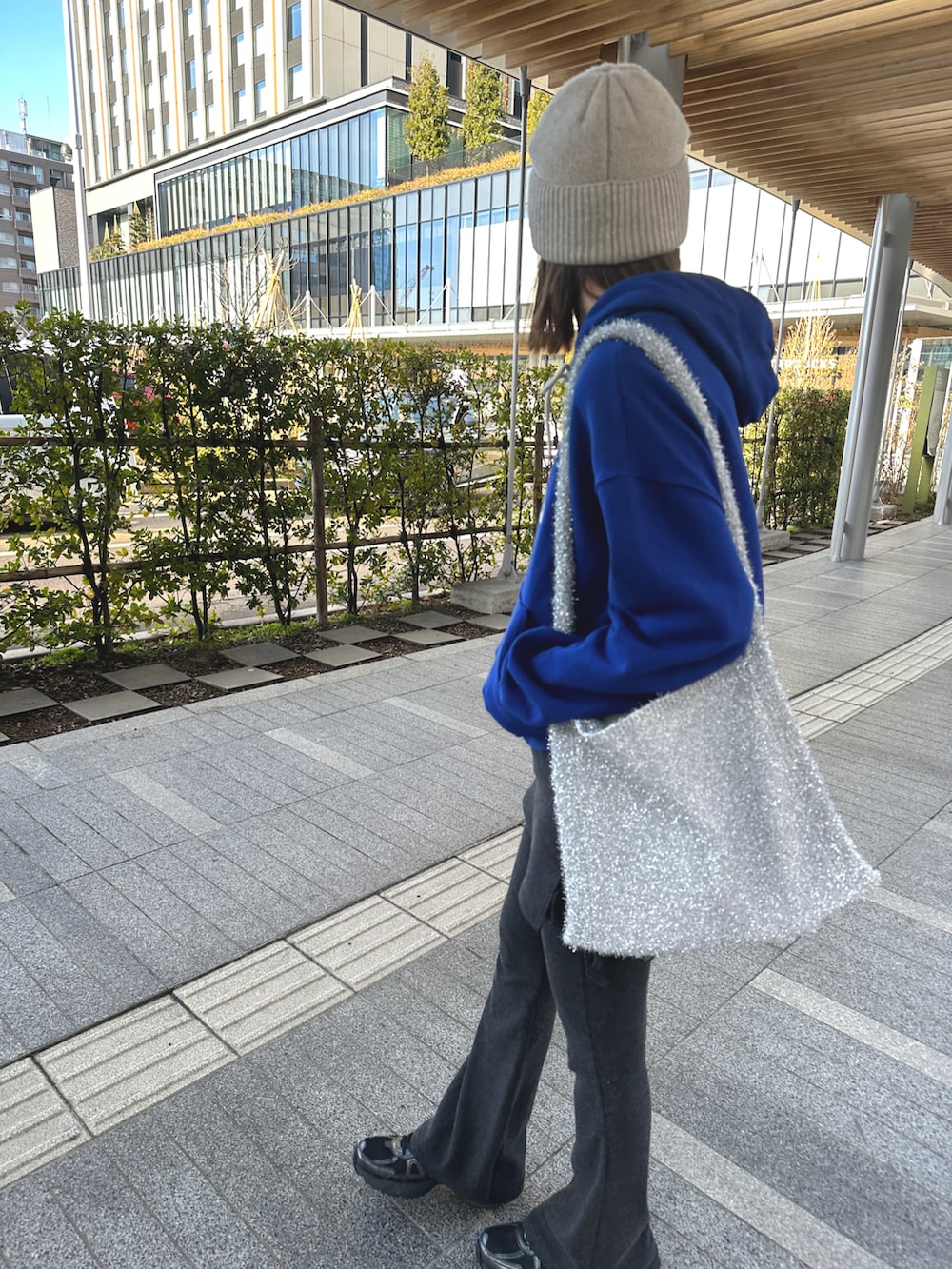 グレー系のパンツ、シルバー系のバッグ、ブラック系のスニーカーを着用したレディースの冬コーディネートの3枚目の写真